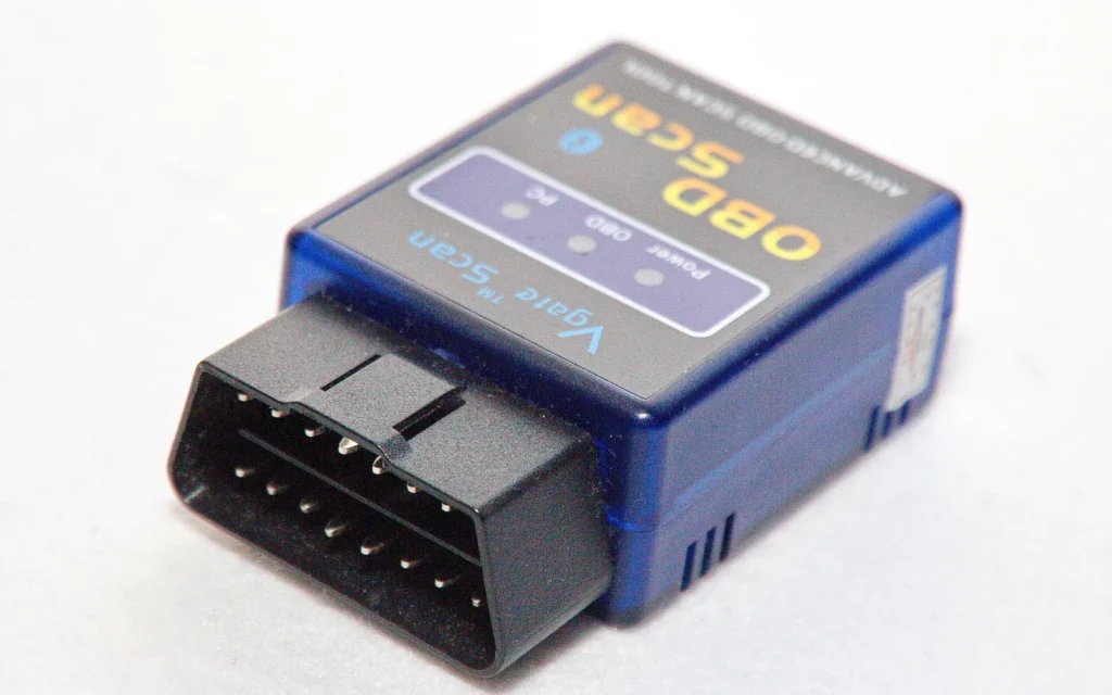 A small OBD-II Bluetooth scan adapter beside its packaging
